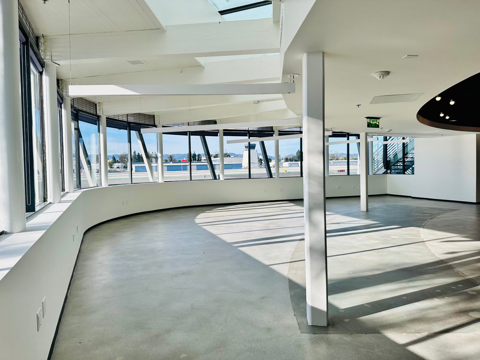 Suite 3221 A — curved window wall with runway and control tower views